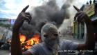 PHOTO: Haitian Street Protester with baricade of fire behind him