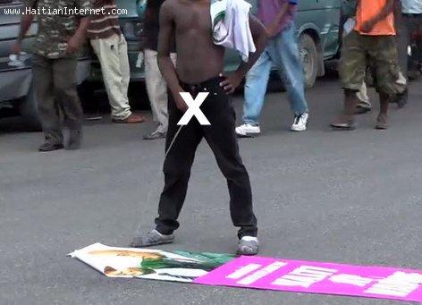 Haitian Protester Urinates on a Martelly-Lamothe Poster